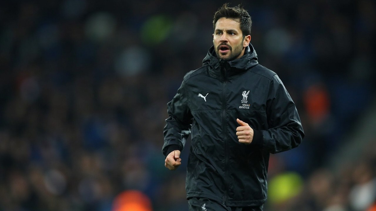 Joao Pedro in a dark training top jogging on the touchline at a floodlit Premier League stadium before kickoff
